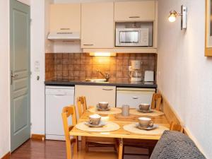a small kitchen with a wooden table and chairs at Appartement Le Dévoluy, 2 pièces, 4 personnes - FR-1-504-522 in Superdevoluy