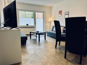 a living room with a television and a couch at FeWo Am Hang mit Balkon im Grünen in Bad Bentheim