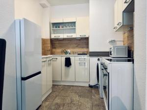 a kitchen with white appliances and a white refrigerator at FeWo Am Hang mit Balkon im Grünen in Bad Bentheim +16 photos