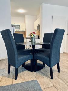a black dining room table with chairs and a vase of flowers at FeWo Am Hang mit Balkon im Grünen in Bad Bentheim