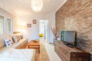 sala de estar con TV y pared de ladrillo en Countryside paradise in Bucelas, en Bucelas