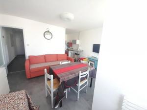 uma sala de estar com uma mesa e um sofá vermelho em Appartement Saint-Hilaire-de-Riez, 2 pièces, 4 personnes - FR-1-324A-27 em Saint-Hilaire-de-Riez