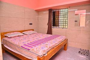 a bed with two pillows in a bedroom at Selva Homestay in Kanchipuram