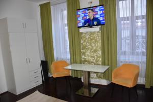 un soggiorno con TV, tavolo e sedie di Old Center - Cozy Corner # 2 a Braşov