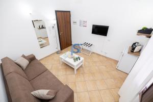 ein Wohnzimmer mit einem Sofa und einem TV in der Unterkunft Ni Ni Apartments - Self Check in in Cefalú