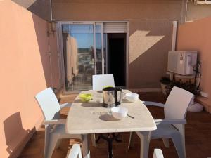 stół jadalny z białymi krzesłami i biały blat stołu i krzeseł w obiekcie Duplex climatisé 4 pers, balcon, parking privé, proche plages et commerces - FR-1-335-168 w Hyères +7 zdjęć