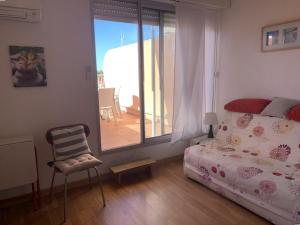 sypialnia z łóżkiem i krzesłem oraz balkon w obiekcie Duplex climatisé 4 pers, balcon, parking privé, proche plages et commerces - FR-1-335-168 w Hyères
