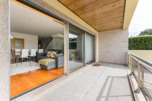 einen Balkon mit Glasschiebetüren und ein Wohnzimmer in der Unterkunft GuestReady - Sophistication and refinement in Vila Nova de Gaia