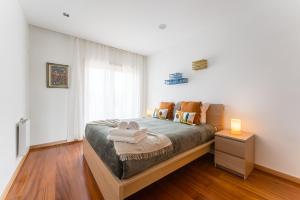 a bedroom with a bed with towels on it at GuestReady - Sophistication and refinement in Vila Nova de Gaia
