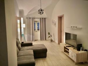 uma sala de estar com um sofá e uma televisão de ecrã plano em Sunny respite in Evora em Reguengos de Monsaraz