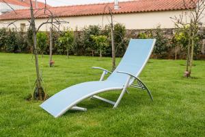 a blue chair sitting in the grass in a yard at Retro-modern retreat in Esposende in Esposende +63 photos