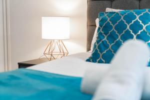 Cama con almohada azul y lámpara en Fabulous Birmingham City Centre 2 Bedroom Apartment - Private Terrace - Top Rated - 004H en Birmingham
