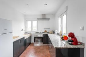 a large white kitchen with a counter top at Retro-modern retreat in Esposende in Esposende