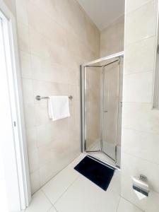 um chuveiro com uma porta de vidro na casa de banho em Lovely flat close to St julians with 6 beds in 3 rooms for 8 people em Is-Swieqi
