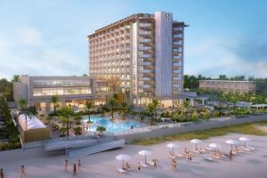 ein Gebäude mit Pool und Menschen, die um ihn herum laufen in der Unterkunft Renaissance Daytona Beach Oceanfront Hotel in Daytona Beach