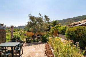 un patio con tavolo e sedie in giardino di Paraíso dos viajantes do tempo em Góis 