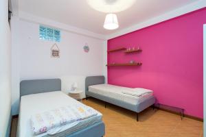 two beds in a room with a pink wall at Paraíso dos viajantes do tempo em Góis 