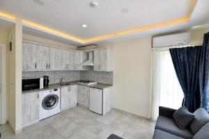 eine Küche mit Waschmaschine und Trockner im Zimmer in der Unterkunft Lamira Apart Holiday&Guest House in Fethiye