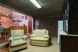 a living room with two chairs and a refrigerator at Paraíso dos viajantes do tempo em Góis 