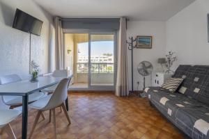 a living room with a bed and a table and a dining room at appartement pour 4 personnes in Saint-Mandrier-sur-Mer