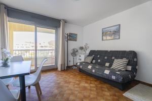 a living room with a bed and a table and a balcony at appartement pour 4 personnes in Saint-Mandrier-sur-Mer