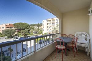 a balcony with a table and chairs and a view of a city at appartement pour 4 personnes in Saint-Mandrier-sur-Mer