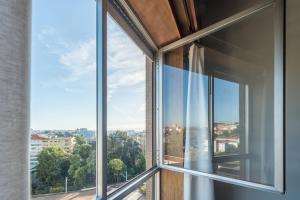 ein offenes Fenster mit Stadtblick in der Unterkunft GuestReady - Woodwork Apartment in Porto