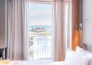 una camera da letto con una grande finestra con vista sull'oceano di Das Ahlbeck Hotel & SPA a Ahlbeck