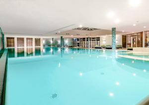 a large swimming pool in a hotel with blue lighting at Das Ahlbeck Hotel & SPA in Ahlbeck