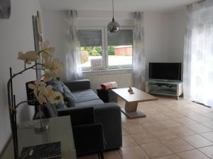 Una sala de estar con un sofá y un televisor. en Bungalow Waldglück, en Hage 14 fotos más