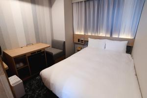 a hotel room with a white bed and a desk at R&B Hotel Otsuka Eki Kitaguchi in Tokyo