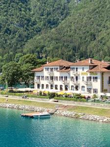 duży budynek z łodzią w wodzie w obiekcie Hotel Lido w mieście Ledro