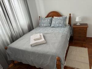 a bedroom with a bed with two towels on it at Cabo Sardão Guest House in Odemira