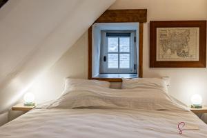 una camera da letto con un letto bianco con una finestra di La maison du Cocher a Pleyber-Christ Altre 12 foto