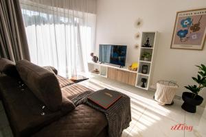 ein Wohnzimmer mit einem Sofa und einem TV in der Unterkunft Mensija Valley Residences in St Julian's
