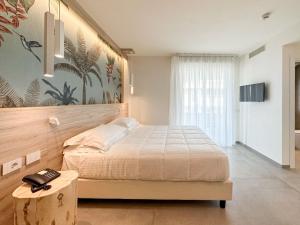 a bedroom with a large bed and a table at Bellettini Hotel in Milano Marittima