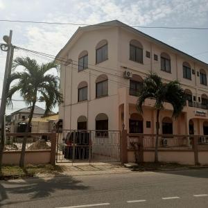 a building with two palm trees in front of it at Estepona Playa Hostel in Accra
