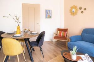 ein Wohnzimmer mit einem Tisch und einem blauen Sofa in der Unterkunft La Robertsau, Lumineux, Paisible in Straßburg