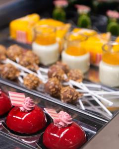 a buffet of food with red peppers and other foods at Bellettini Hotel in Milano Marittima