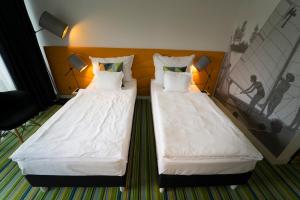 dos camas sentadas una al lado de la otra en una habitación en Fenyves Yacht Club Superior en Balatonfenyves