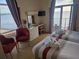 a hotel room with two beds and a view of the ocean at Redcliffe Hotel in Paignton