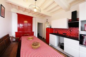 cocina con mesa y mantel rojo y blanco en La Belle Etoile - Maison avec grand jardin, en Hauteville-sur-Mer