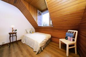 1 dormitorio con paredes de madera, 1 cama y ventana en La Belle Etoile - Maison avec grand jardin, en Hauteville-sur-Mer