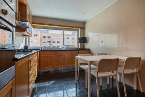 uma cozinha com uma mesa branca e cadeiras em 2 Bedroom Large apartment By Innkeeper em Lisboa