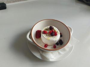 un bol de crème glacée et de baies sur une assiette dans l'établissement B&B De Janas, à La Caletta