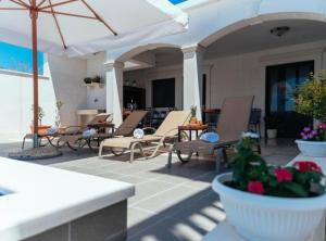 a patio with lounge chairs and an umbrella at Apartments Trogrlić in Hvar