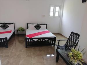 una camera con due letti e una sedia di Hotel Water Nest a Etagama
