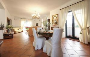 een eetkamer met een tafel en witte stoelen bij Pet Friendly Home In Pozzuoli With Outdoor Swimming Pool in Pozzuoli