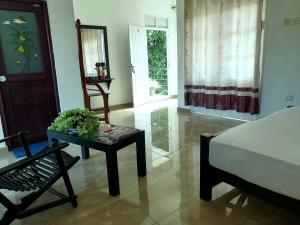 a bedroom with a bed and a table and a chair at Hotel Water Nest in Etagama