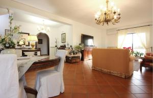 un soggiorno con lampadario pendente, tavolo e sedie di Gorgeous Home In Pozzuoli With Kitchen a Pozzuoli